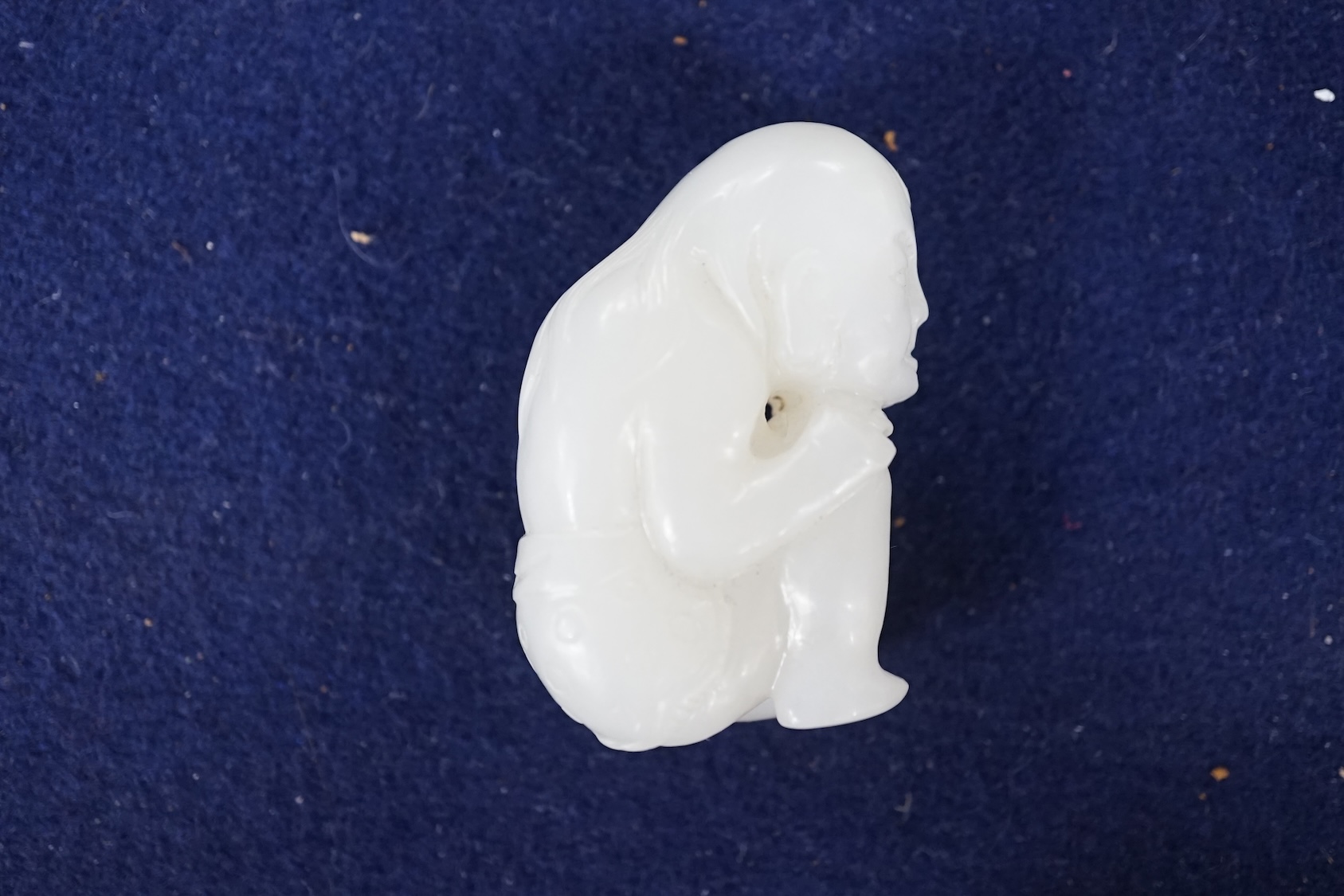 A Chinese white jade carving of a crouching figure, 4.5cm high. Condition - good